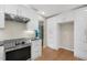 Stylish kitchen with white cabinets, stainless steel range hood, stainless steel appliances and hardwood floors at 2511 Bexley Ave, Durham, NC 27707