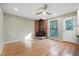 Bright living room with a brick fireplace, hardwood floors, and a ceiling fan at 2511 Bexley Ave, Durham, NC 27707