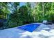 A captivating in-ground pool surrounded by lush greenery and a stone outdoor oven at 2511 Bexley Ave, Durham, NC 27707