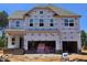 New construction home with a two-car garage and visible framing, set against a clear blue sky at 30 Bold Dr, Youngsville, NC 27596
