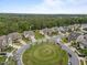 Aerial view of homes surrounding a landscaped traffic circle with mature trees and green space at 302 Kinney Glenn Ct, Durham, NC 27713