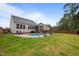 Full backyard view including pool, sunbathing chairs, screened porch, and backyard fence at 302 Kinney Glenn Ct, Durham, NC 27713