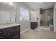 Bathroom with double sinks, granite counters, window, and glass shower at 302 Kinney Glenn Ct, Durham, NC 27713