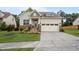 Inviting home featuring a manicured lawn, stone details, and a convenient two-car garage at 302 Kinney Glenn Ct, Durham, NC 27713