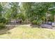 Large grassy backyard featuring a storage shed and treelined perimeter at 311 Pate St, Apex, NC 27502