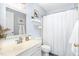 Bright bathroom featuring a vanity, toilet, and shower with a white shower curtain at 311 Pate St, Apex, NC 27502