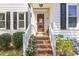 Charming brick steps lead to a welcoming front door adorned with decorative plants and stylish fixtures at 311 Pate St, Apex, NC 27502