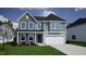 Charming two-story home with a two-car garage, manicured lawn and beautifully designed green and gray exterior at 316 Alice Trace Place, Angier, NC 27501