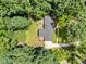 Aerial view of home surrounded by lush trees, featuring a well-manicured lawn and a paved driveway at 3204 Manor Ridge Dr, Raleigh, NC 27603