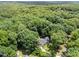 Expansive aerial view of a home enveloped by a dense forest, highlighting the serene setting at 3204 Manor Ridge Dr, Raleigh, NC 27603