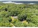 Overhead view of homes surrounded by a dense canopy of trees, with a lake visible in the distance at 3204 Manor Ridge Dr, Raleigh, NC 27603