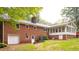 Brick home with a chimney, access to garage and a sunroom at 3204 Manor Ridge Dr, Raleigh, NC 27603