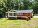 A house with a brick exterior, a deck, and a sunroom surrounded by lush greenery at 3204 Manor Ridge Dr, Raleigh, NC 27603