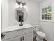 Bright white bathroom features a modern vanity, updated fixtures, and a window at 3204 Manor Ridge Dr, Raleigh, NC 27603