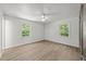Airy bedroom with light wood-look floors, a ceiling fan, and a large window at 3204 Manor Ridge Dr, Raleigh, NC 27603