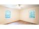 Neutral bedroom with two windows, wood-style flooring, a ceiling fan, and white trim at 3204 Manor Ridge Dr, Raleigh, NC 27603