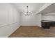 An open dining room with modern chandelier, dark hardwood floors, and bar area at 3204 Manor Ridge Dr, Raleigh, NC 27603
