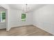 Bright and airy dining room with wood floors, white walls, and a modern light fixture at 3204 Manor Ridge Dr, Raleigh, NC 27603