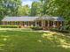 A spacious brick home with a manicured lawn, black shutters, and a covered front porch at 3204 Manor Ridge Dr, Raleigh, NC 27603
