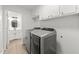 Bright laundry room features new washer and dryer, white cabinets, and neutral flooring at 3204 Manor Ridge Dr, Raleigh, NC 27603