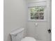 Simple half bath features a toilet, small window, and a charming toilet paper holder at 3204 Manor Ridge Dr, Raleigh, NC 27603