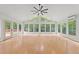 Large sunroom features floor-to-ceiling windows, hardwood floors, and a ceiling fan at 3204 Manor Ridge Dr, Raleigh, NC 27603