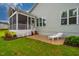 View of the home's back exterior, showing the screened-in porch, patio and white lounge chair on the lawn at 328 Boone St, Chapel Hill, NC 27516