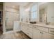 Bright bathroom featuring dual sinks, white cabinets, large mirror, and shower with glass door at 328 Boone St, Chapel Hill, NC 27516