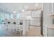 Modern white kitchen featuring a breakfast bar, stainless steel appliances, and stylish pendant lighting, creating an inviting space at 328 Boone St, Chapel Hill, NC 27516