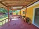 Covered wooden deck with built-in bench seating overlooking the backyard and shed at 3612 Satellite Ct, Raleigh, NC 27604