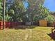 Fenced backyard featuring mature trees, green grass, and yellow storage shed at 3612 Satellite Ct, Raleigh, NC 27604