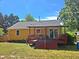 View of the backyard with a wooden deck, red stairs, and yellow home siding at 3612 Satellite Ct, Raleigh, NC 27604