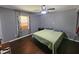 Simple bedroom featuring a window, hardwood floors, and a bed with blue pillows at 3612 Satellite Ct, Raleigh, NC 27604