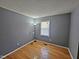 Neutral bedroom featuring hardwood flooring and a window with blinds at 3612 Satellite Ct, Raleigh, NC 27604