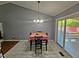Dining area with a chandelier and sliding doors leading to the backyard, next to the living room at 3612 Satellite Ct, Raleigh, NC 27604