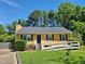 Charming yellow home with well-manicured lawn, accessible ramp, and black shutters at 3612 Satellite Ct, Raleigh, NC 27604