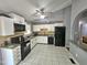 Well-lit kitchen featuring white cabinets, black appliances, granite counters and tile flooring at 3612 Satellite Ct, Raleigh, NC 27604
