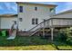Back exterior of a two-story home with wooden deck, stairs and a grassy yard at 3708 Mackinac Island Ln, Raleigh, NC 27610