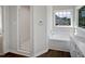 Bathroom featuring a bathtub and shower with a glass door, set beneath a window at 3708 Mackinac Island Ln, Raleigh, NC 27610