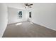 A bright empty bedroom with neutral carpet, two windows and a ceiling fan at 3708 Mackinac Island Ln, Raleigh, NC 27610
