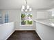 Cozy dining area with modern chandelier, large window, and adjacent bar-style counter with cabinets at 3708 Mackinac Island Ln, Raleigh, NC 27610
