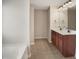 Bathroom with double sinks, cherry cabinets, and tile flooring near a large tub at 3709 Althorp Dr, Raleigh, NC 27616