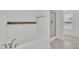 Bathroom with soaking tub, tiled walls, wooden shelf, and tiled floors, offering a clean and modern look at 384 Grey Hawk Dr, Garner, NC 27529