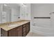 Bathroom featuring double sinks, granite countertops, a large mirror, and a soaking tub at 384 Grey Hawk Dr, Garner, NC 27529