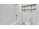 Bathroom featuring a bathtub with shower and custom wood shelving at 384 Grey Hawk Dr, Garner, NC 27529