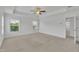 Spacious primary bedroom featuring tray ceiling, neutral carpet and two windows offering natural light at 384 Grey Hawk Dr, Garner, NC 27529