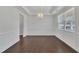Spacious dining room with dark hardwood floors, white trim, and decorative chandelier at 384 Grey Hawk Dr, Garner, NC 27529