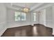 Light filled dining room with decorative chandelier, white trim and hardwood floors at 384 Grey Hawk Dr, Garner, NC 27529