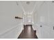Bright hallway with dark wood floors and white wainscoting leads to the front door at 384 Grey Hawk Dr, Garner, NC 27529