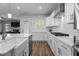 Modern white kitchen features a gas range, stainless appliances, and laminate wood flooring at 412 Kavanaugh Rd, Wake Forest, NC 27587